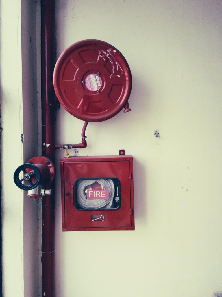 Red fire safety equipment on a white wall, essential for emergencies.