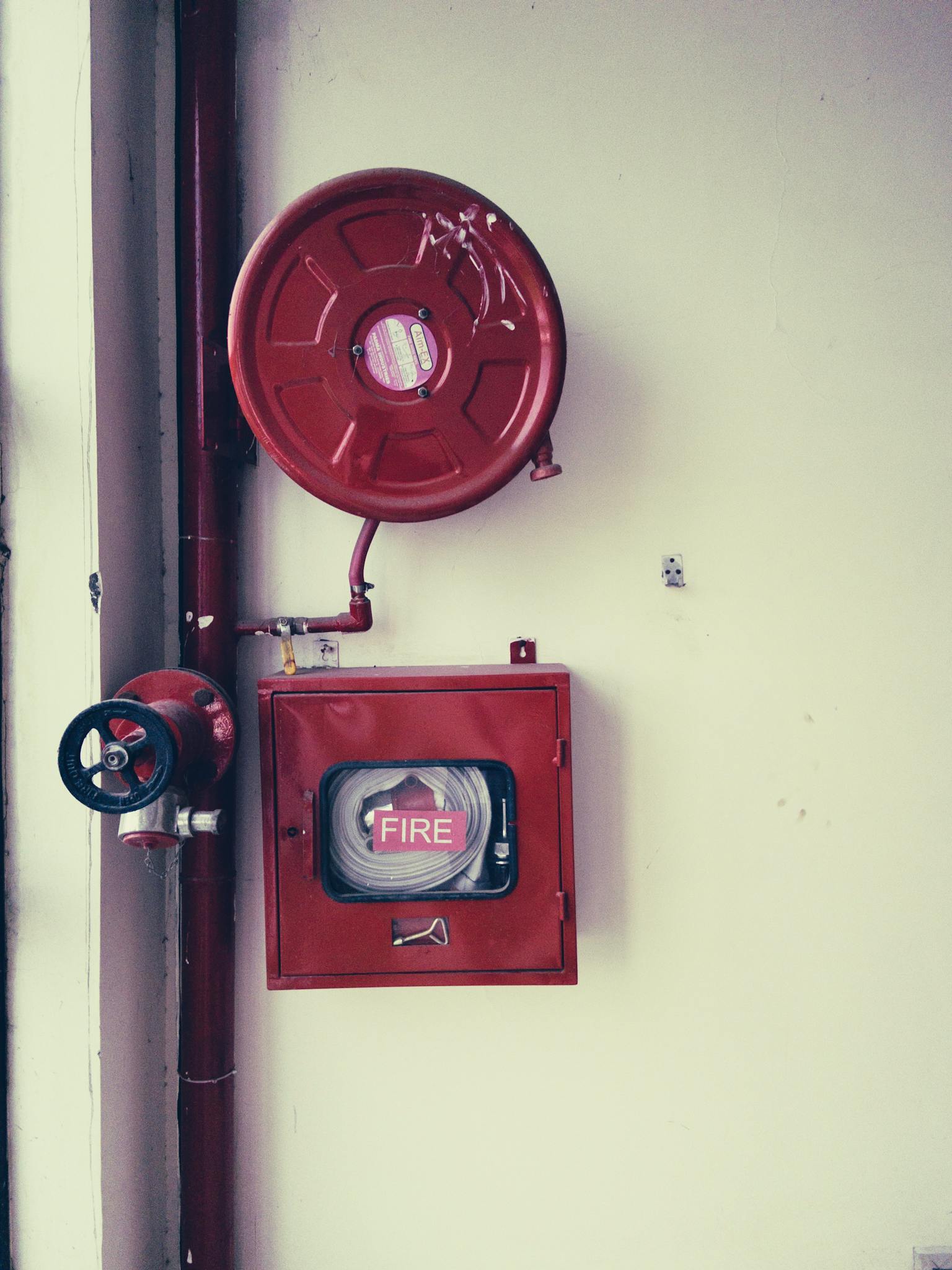 Red fire safety equipment on a white wall, essential for emergencies.